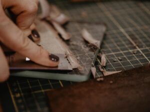 Hands sharpening leather with a knife